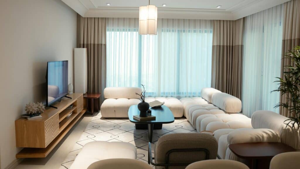 Modern luxury living room with elegant beige furniture, large windows, and natural lighting — aspirational lifestyle concept