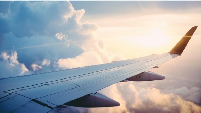 飛行機の翼と雲海、夕日が照らす空の風景