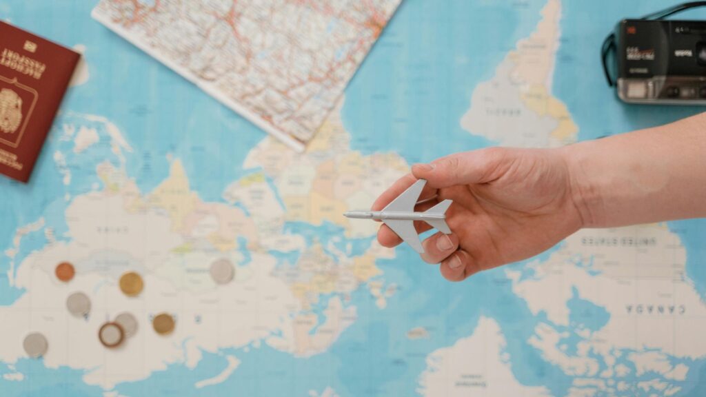 手に持ったEmiratesのエコノミークラス搭乗券と、背景に散らばる複数の搭乗券。