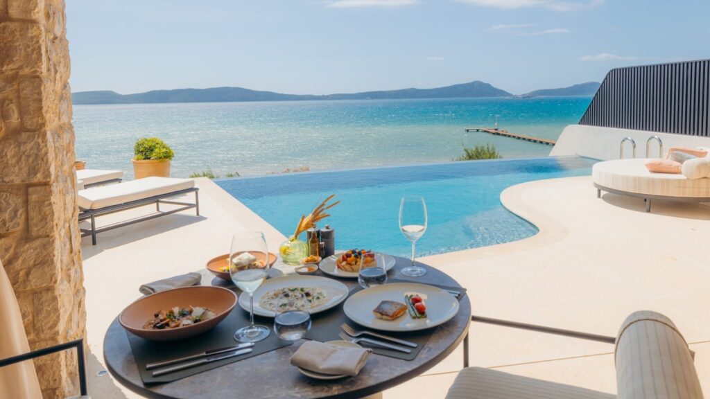 AmexプラチナのFHR特典を紹介するAmex公式写真。海を望むプールサイドのテラスに朝食が並ぶ